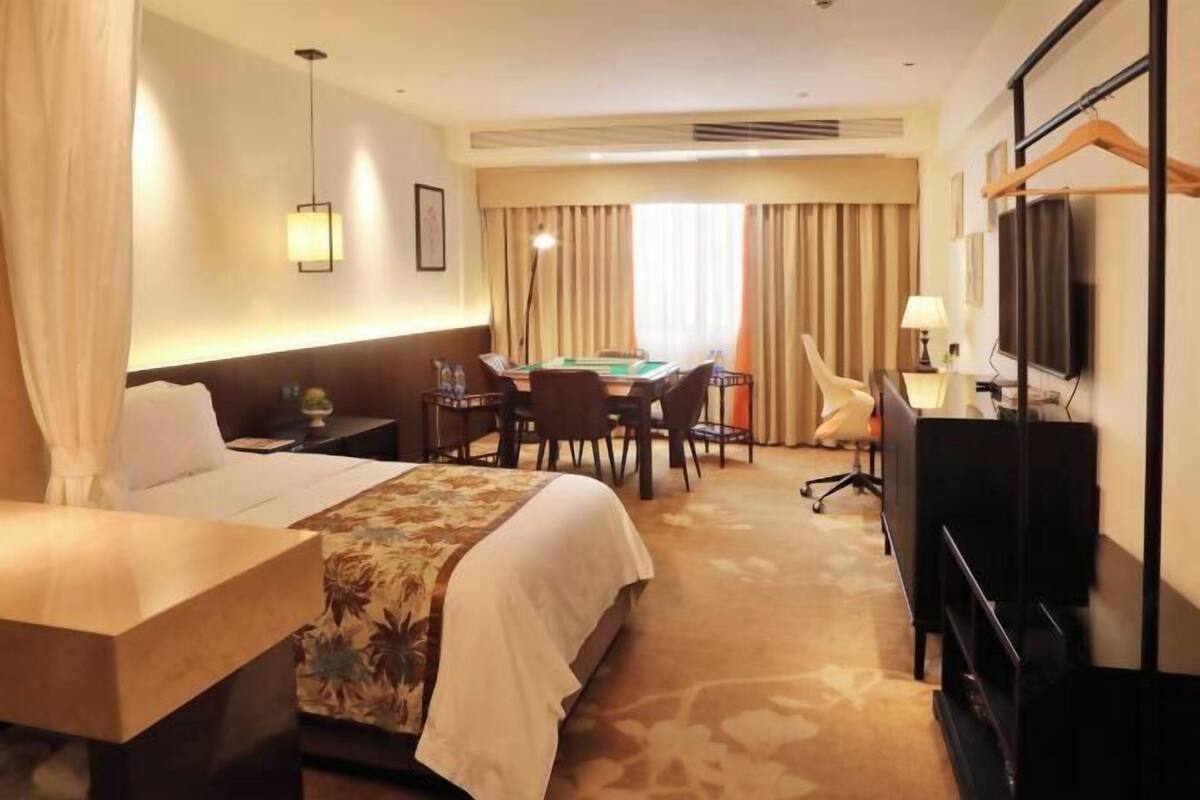 Une chambre d’hôtel équipée d’un lit, d’un bureau, d’une chaise, d’une télévision et d’une table de billard.