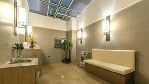 Uma casa de banho moderna com claraboia, lavatório, banco e luzes embutidas na parede.