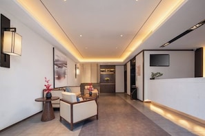 A modern hotel lobby with a reception desk, seating area, and a view into the dining area. - Fairyland Premium Hotel (Kunming Tuodong Sports Center Tangzixiang Metro Station) (Kunming)