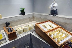 A breakfast buffet with various food items and utensils.