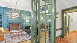 A room with a fireplace, a green door, and a patterned rug.