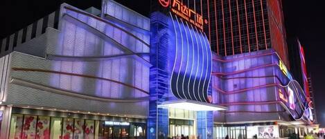 Un edificio moderno con una fachada curva llamativa y señalización iluminada.