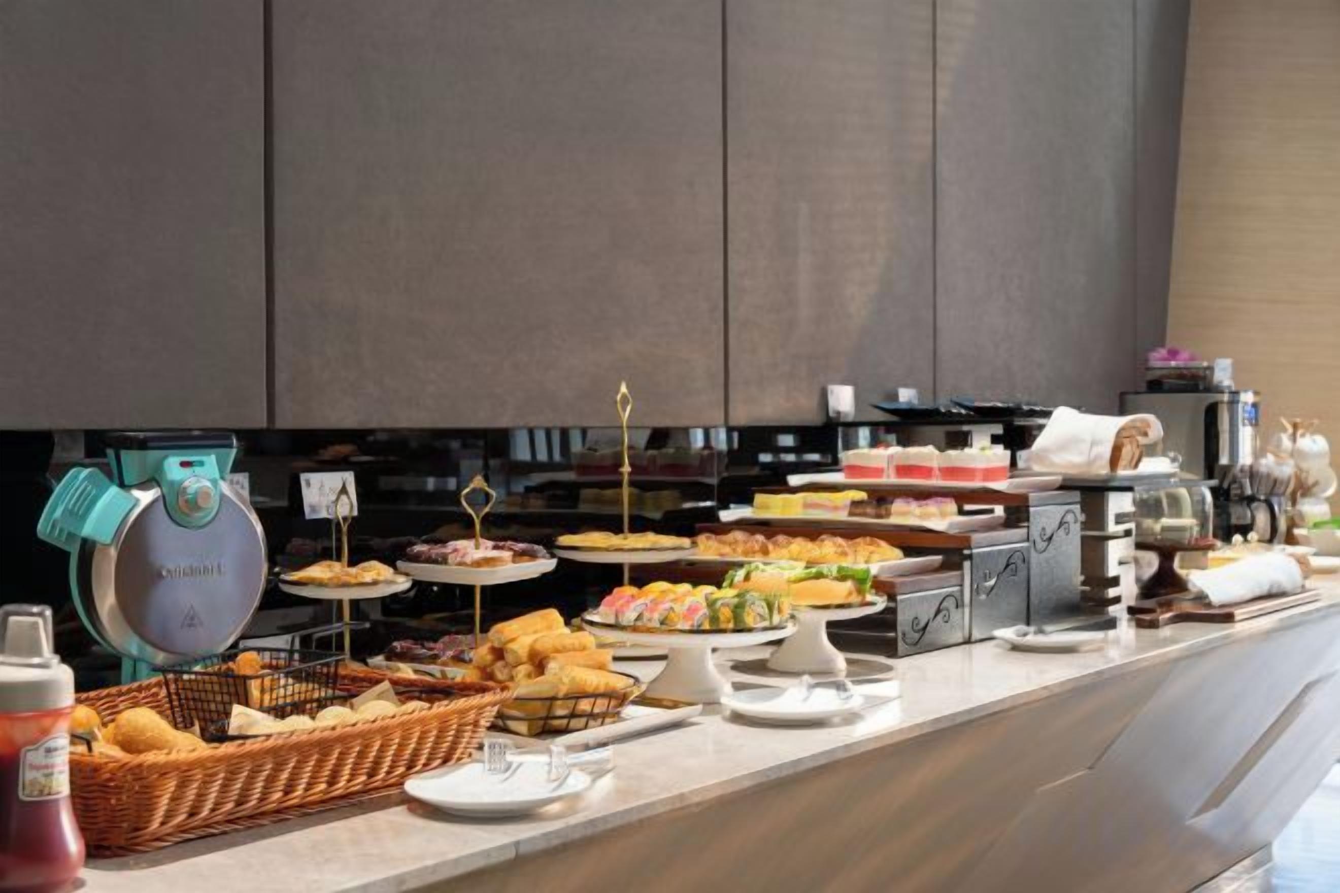 A buffet with various food items and a coffee machine.