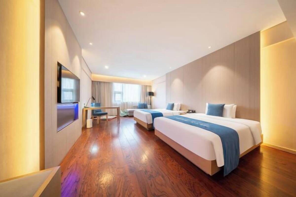Une chambre d’hôtel avec un grand lit, un bureau et une télévision.