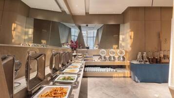 Un buffet avec plusieurs points de service et un espace central dédié aux boissons.