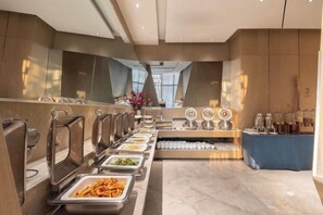 Un buffet avec plusieurs points de service et un espace central dédié aux boissons.