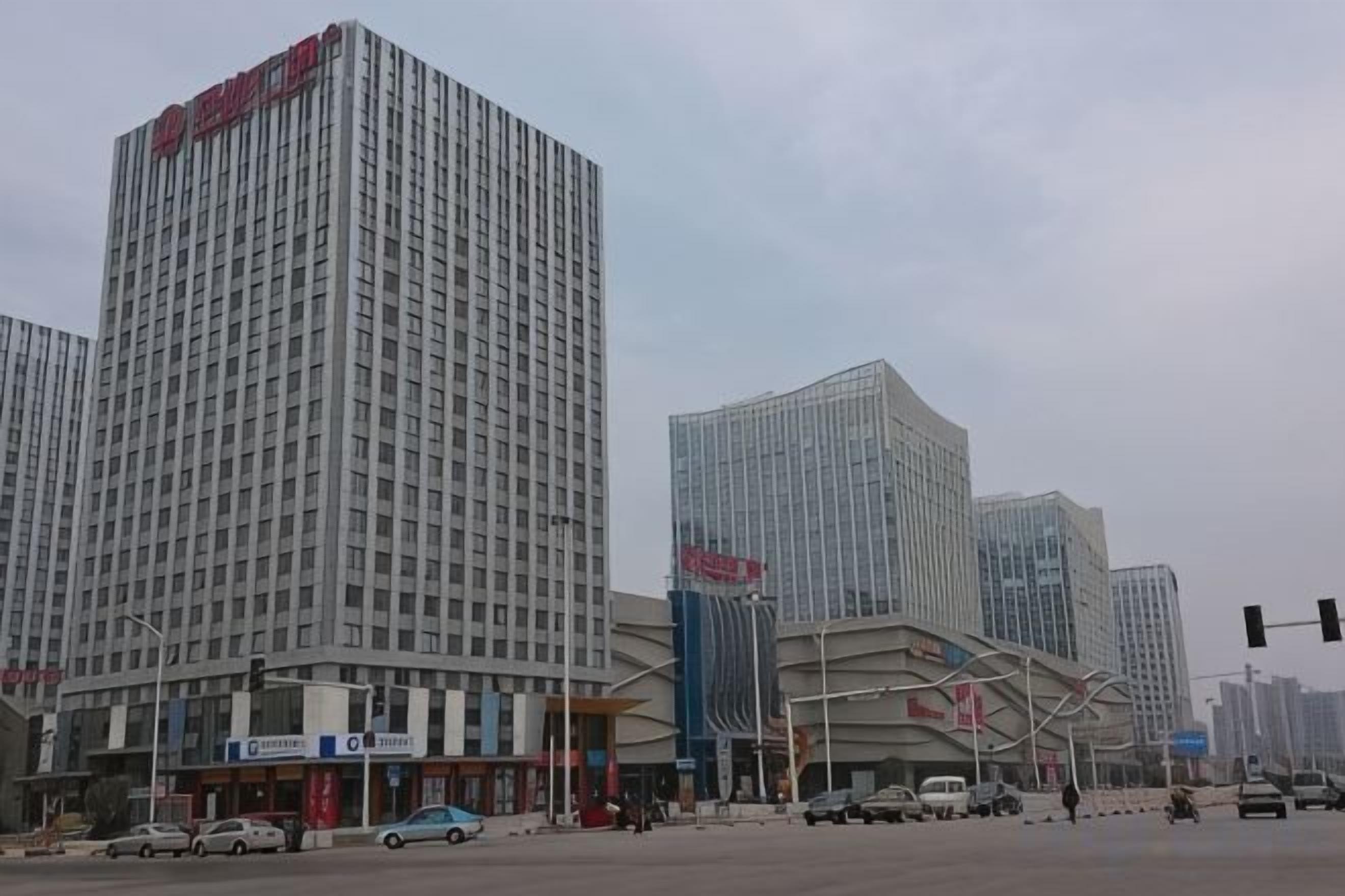 A multi-story building with a modern architectural design, featuring a prominent entrance and a series of windows.