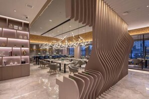 Un intérieur moderne avec un espace salon central, un mur décoratif et un luminaire original.