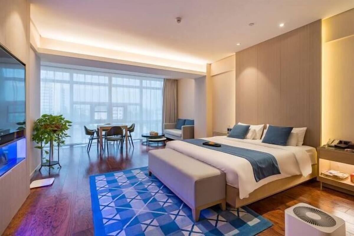 Une chambre d’hôtel moderne équipée d’un grand lit, d’un bureau, d’une chaise et d’une table à manger.