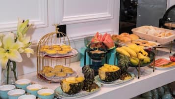 Buffet com diversos alimentos e uma gaiola decorativa.