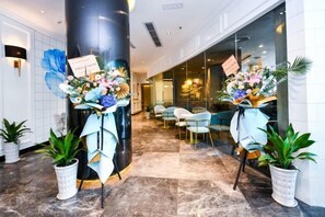 A hotel lobby with a reception desk, seating area, and potted plants. - Xana Hotelle (Shenzhen Luohu Dongmen Yitian Holiday Plaza Hotel） (Shenzhen)