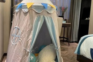 A tent-like structure with a circular window, a small table, and a chair in a room with a wooden floor. - Xana Hotelle (Shenzhen Luohu Dongmen Yitian Holiday Plaza Hotel） (Shenzhen)