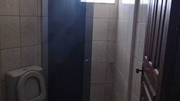 Chuveiro, toalhas de banho, papel higiênico