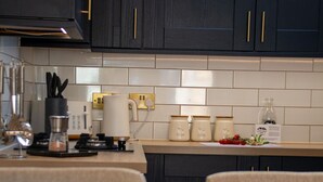 A kitchen with dark cabinets, a countertop with a coffee maker, a toaster, and a glass of orange juice.