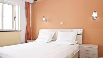 Una habitación de hotel con una cama, mesitas de noche y un aplique de pared.