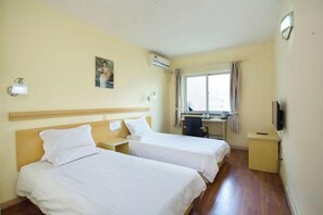 A hotel room with two beds, a desk, a chair, a TV, and a window with curtains. - Rulai Hotel (Shanghai)