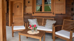A wooden cabin interior with a wooden table, two chairs, a bench, and a window with curtains. - Amazing home in Druzilovec with sauna (Druzilovec)
