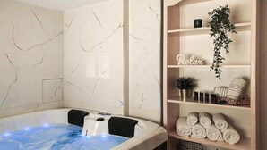 A spa room with a hot tub, shelves with towels, a potted plant, and a shelf with a 'Relax' sign. - Amazing home in Druzilovec with sauna (Druzilovec)
