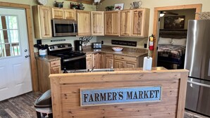 Una cocina con armarios de madera, un refrigerador de acero inoxidable y un cartel que dice "FARMER'S MARKET".