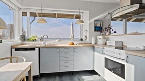 A modern kitchen with a large window, a built-in oven, and a dishwasher. - 3 bedroom gorgeous home in Hejls (Hejls)
