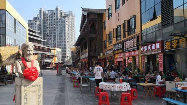 A bustling street scene with outdoor seating and traditional architecture.