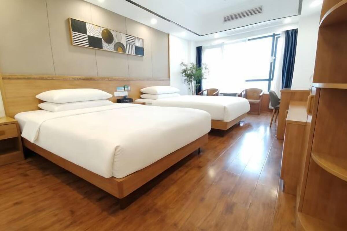 Una habitación de hotel con una cama grande, un escritorio y una silla.