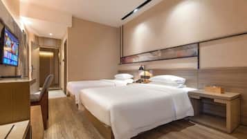 Ein Hotelzimmer mit zwei Betten, einem Schreibtisch, einem Fernseher und einem Wandbild.