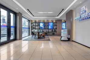 A modern hotel lobby with a reception desk, seating area, and a large digital display. - Rest Comfort Hotel(Shanghai North Bund Ningguo Road Subway Station) (Shanghai)