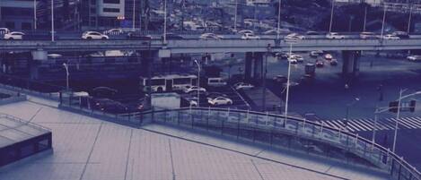A cityscape with a bridge, vehicles, and a pedestrian walkway.