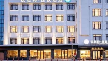 A hotel building with multiple floors, large windows, and a sign indicating it is a hotel.