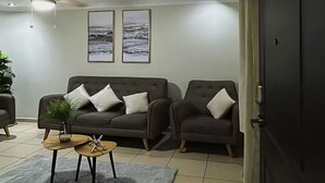A living room with two sofas, a coffee table, and a ceiling fan. - Residencia Cálida y acogedora (Santa Tecla)