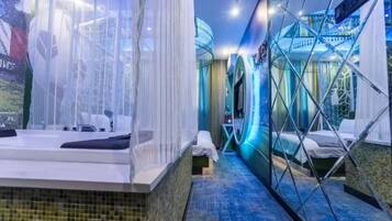 A modern hotel room with a large bathtub, a separate shower area, and a glass partition.