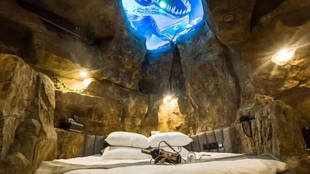 A cave-like room with a bed, pillows, and a ceiling light fixture. - Mt Theme Hotel Shanghai (Shanghai)