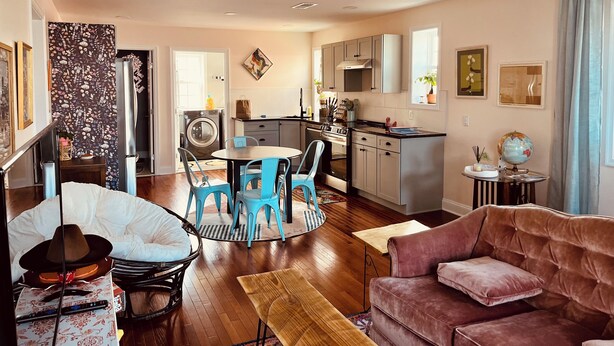 Una cocina moderna con comedor, una sala de estar con sofá y un ventilador de techo.
