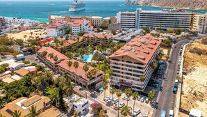 A coastal hotel with multiple buildings, a swimming pool, and a view of the sea and a cruise ship. - 1 Bdrm, 2 Baths!!!! This is a larger 2 bdrm, chng'd to a 1 Bdrm!   MUCH LARGER!! (Cabo San Lucas)