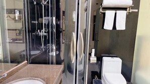 A bathroom with a glass shower enclosure, a white toilet, and a sink with a marble countertop. - Super 8 (Beijing Yizhuang Kechuang Jiujie) (Beijing)