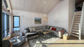 A cozy living room with a grey sectional sofa, a coffee table, a patterned rug, and a wooden ceiling. - Gorgeous home in Kvam with sauna (Kvam)