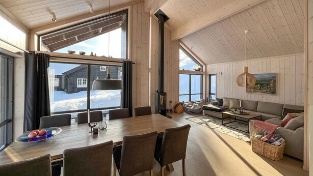 A spacious living area with a large wooden table, comfortable seating, and a view of a snowy landscape through large windows. - Gorgeous home in Kvam with sauna (Kvam)