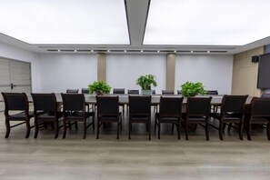 A conference room with a long table, chairs, potted plants, and a flat-screen TV. - Homeinn Selected Hotel (Enshi Tusi City ) (Enshi City)