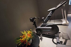 Una bicicleta estática con un arreglo floral a un lado.