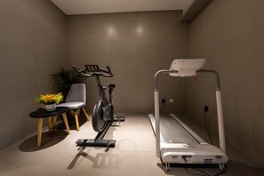 A room with a treadmill, a chair, and a small table with a potted plant. - Homeinn Selected Hotel (Enshi Tusi City ) (Enshi City)