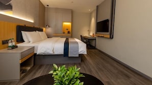 A modern hotel room with a bed, bedside table, TV, and a small desk with a chair. - Homeinn Selected Hotel (Enshi Tusi City ) (Enshi City)