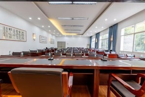 A conference room with multiple tables and chairs, large windows, and ceiling lights. - Homeinn Selected Hotel (Enshi Tusi City ) (Enshi City)