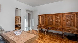 Quarto com armário de madeira, espelho e chão de azulejos.