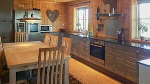 Une cuisine moderne avec des meubles en bois, une décoration en forme de cœur et un coin repas comprenant une table et des chaises en bois.
