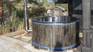Un grand baril en métal, muni d’une chaîne, posé sur une terrasse en bois.