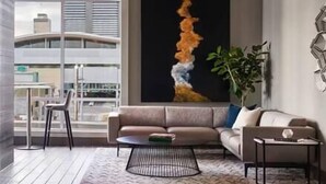 Un salon moderne avec un canapé, une table basse et un grand tableau abstrait.