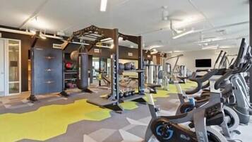 Ein Fitnessstudio mit verschiedenen Trainingsgeräten, darunter Laufbänder und Kraftgeräte.
