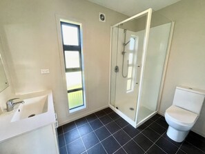 A bathroom with a shower, toilet, and sink.