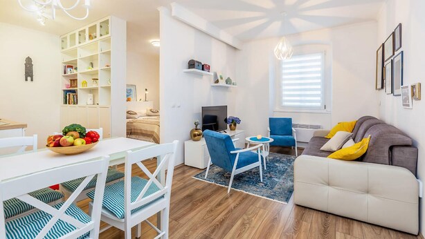 Un salon moderne comprenant un coin repas, un canapé, un téléviseur et une bibliothèque.